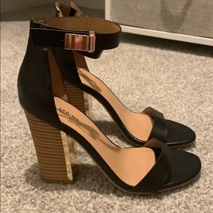 Black sandals with wood heels and gold buckles